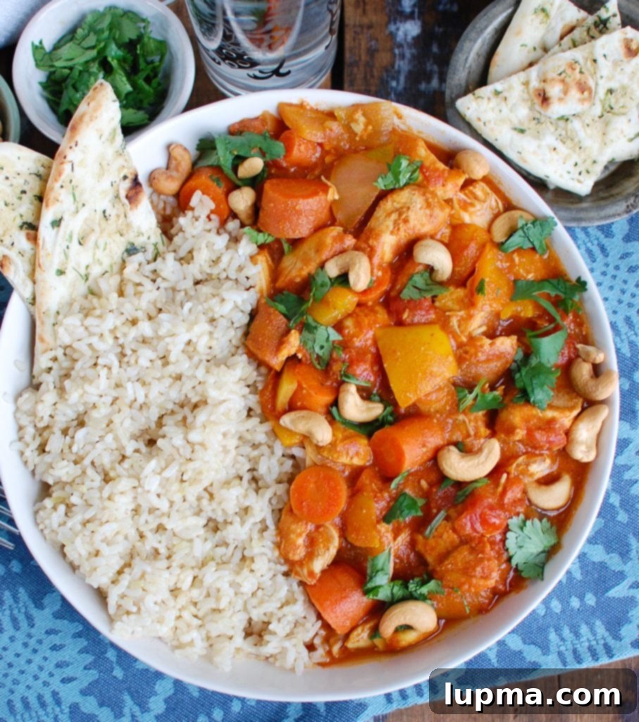 Effortless Slow Cooker Chicken Curry 3 Overhead shot of Slow Cooker Coconut Curry Chicken in a white bowl, garnished with fresh cilantro.