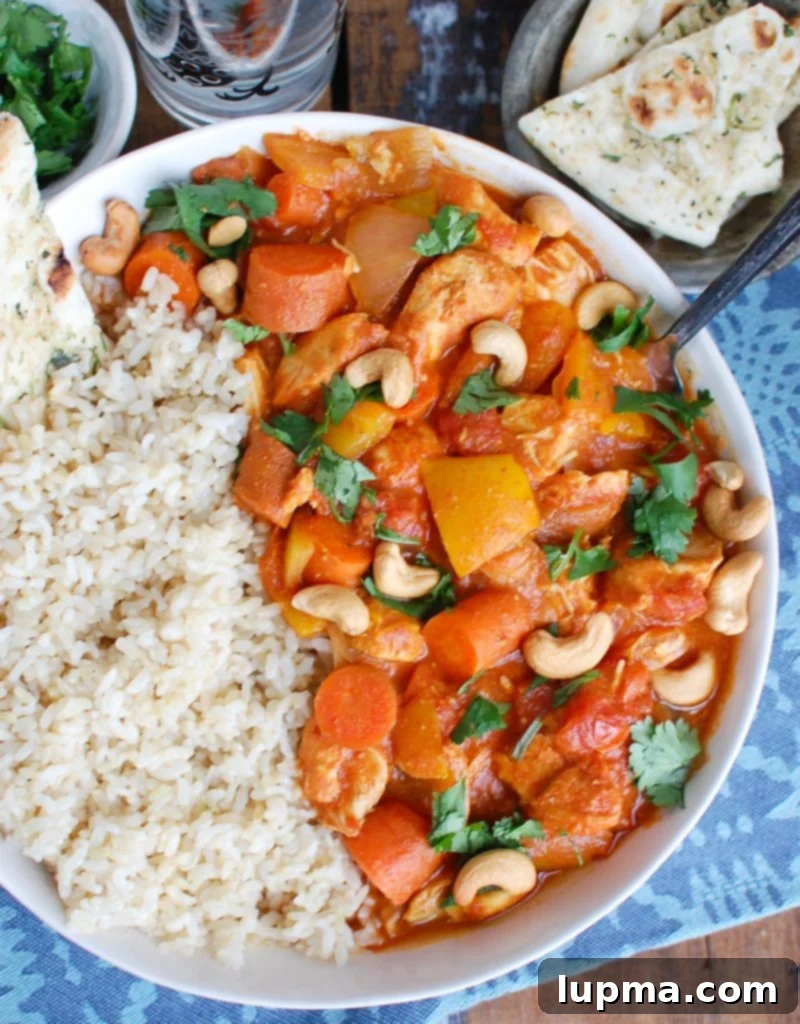 Effortless Slow Cooker Chicken Curry 4 A spoon scooping up Slow Cooker Coconut Curry Chicken from a bowl.