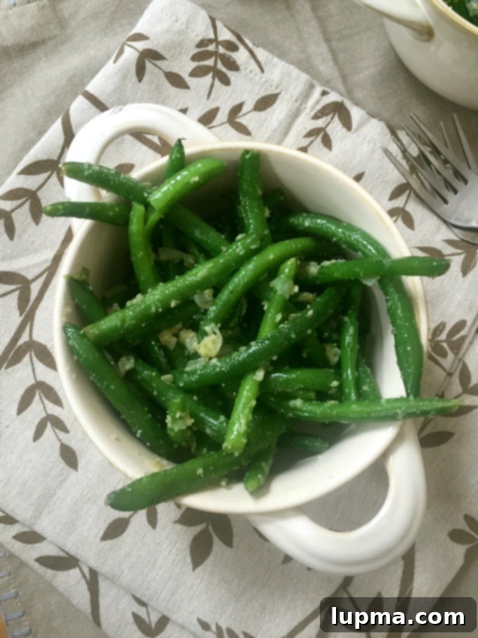 Effortless Garlic Parmesan Green Beans 2 Freshly cooked garlic parmesan green beans in a serving dish, ready to eat.