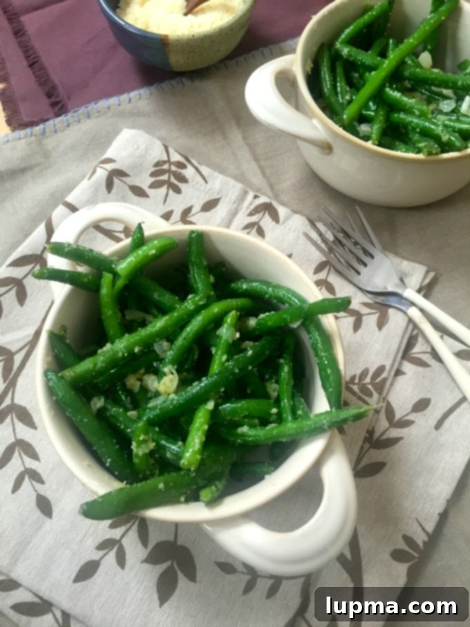Effortless Garlic Parmesan Green Beans 3 Close-up of vibrant green beans tossed with garlic and butter, sprinkled with parmesan cheese.