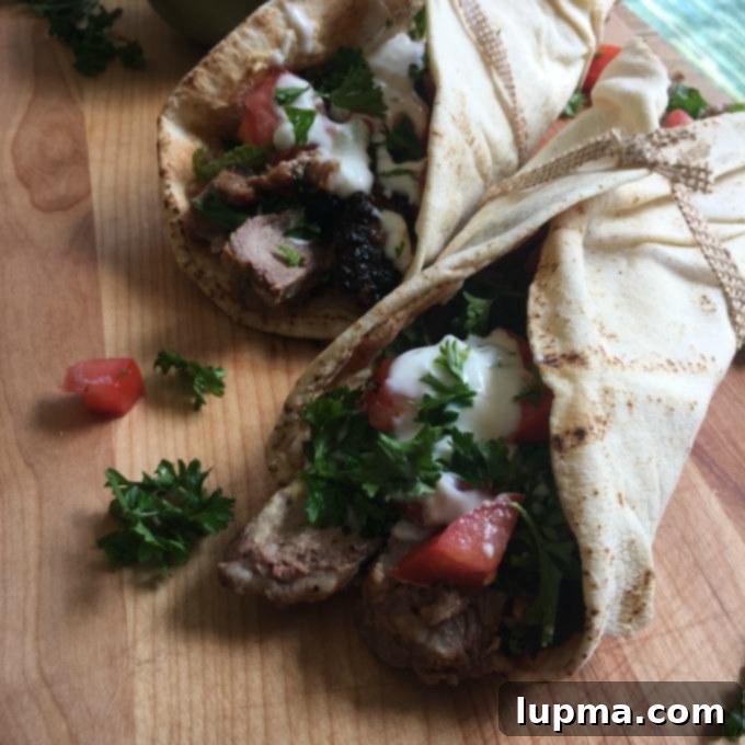 Zesty Mediterranean Steak Pitas with Cooling Mint Yogurt 3 Mediterranean Steak Pita Wrap with Mint Yogurt Sauce on cutting board.