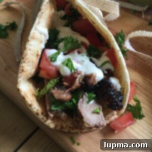 Zesty Mediterranean Steak Pitas with Cooling Mint Yogurt 7 Mediterranean Steak Pita Wrap with Mint Yogurt Sauce on cutting board.
