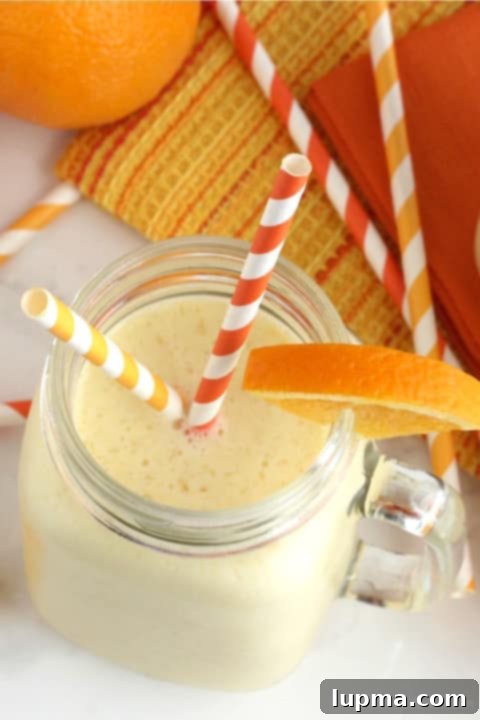 11 Irresistibly Refreshing Smoothies 13 A refreshing Pineapple Orange Creamsicle Smoothie in a tall glass, garnished with fruit.