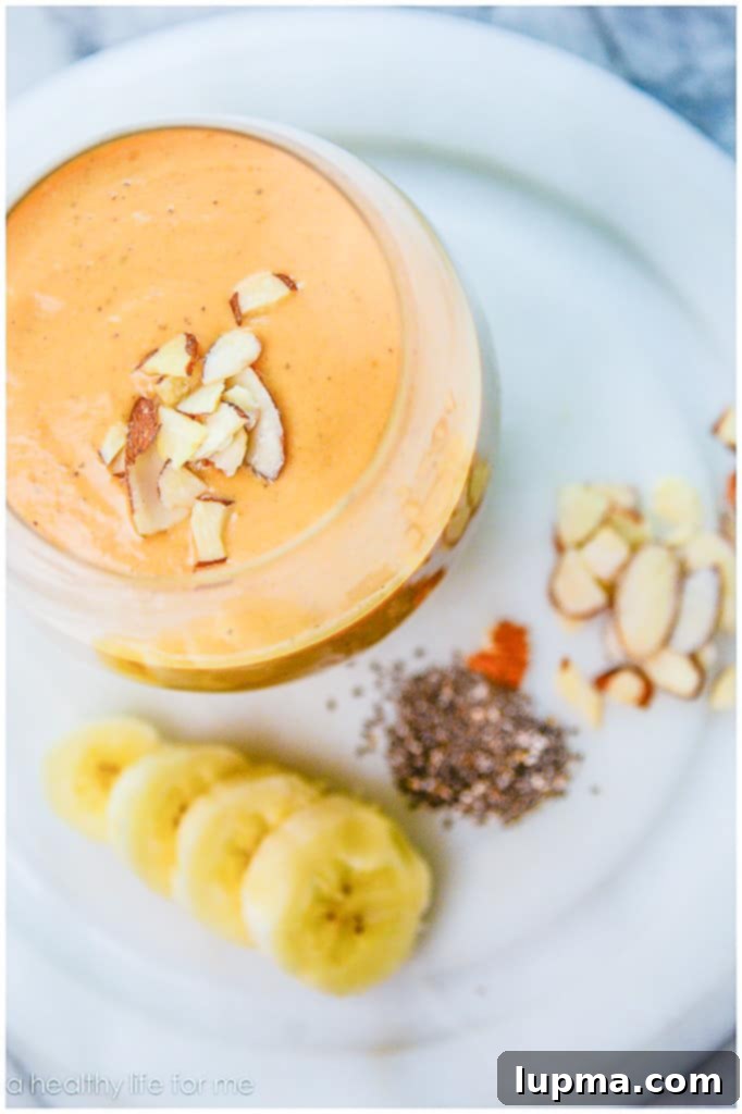 11 Irresistibly Refreshing Smoothies 6 A festive Pumpkin Banana Vanilla Smoothie in a glass jar, garnished with a cinnamon stick.