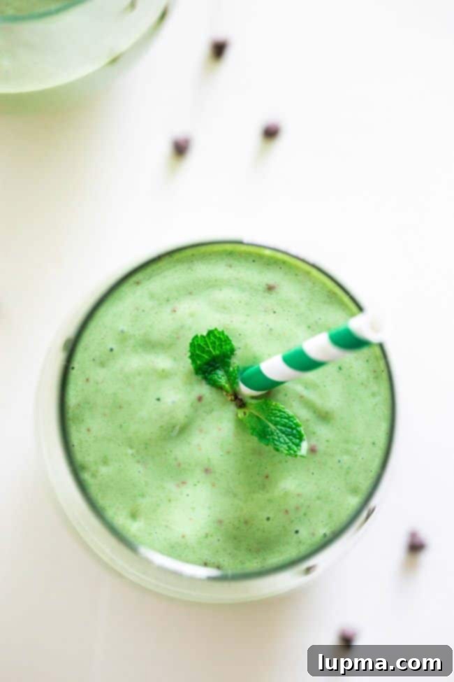 11 Irresistibly Refreshing Smoothies 7 A vibrant green Mint Chocolate Green Smoothie in a glass, topped with chocolate shavings.