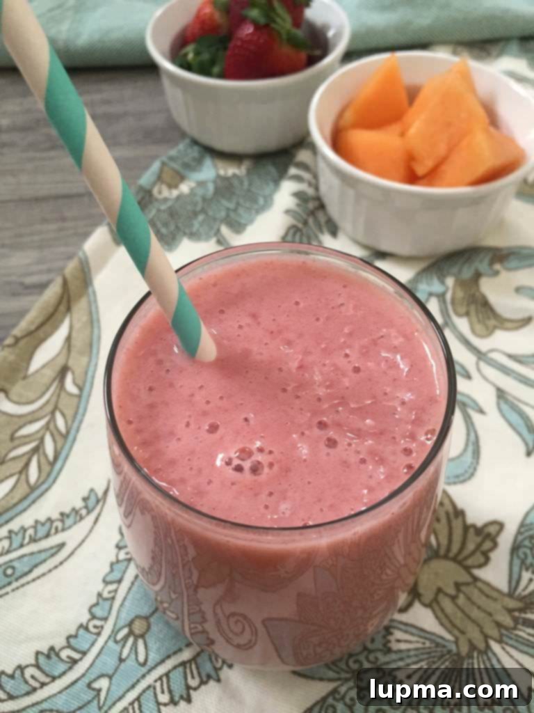 11 Irresistibly Refreshing Smoothies 9 A bright, cheerful Strawberry Cantaloupe Smoothie in a glass with a straw.
