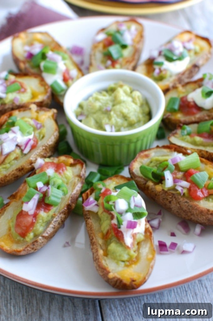Zesty Guacamole Potato Skins 3 Two Guacamole Stuffed Potato Skins on a white plate, showcasing the vibrant green guacamole.