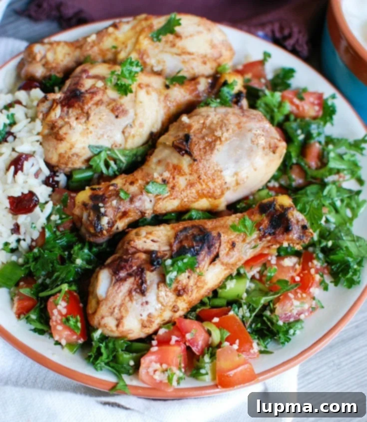 Herbed Mediterranean Chicken with Basmati Rice 2 Close-up of grilled Mediterranean chicken drumsticks served atop herbed basmati rice, garnished with fresh tabbouleh for a healthy and vibrant summer meal.