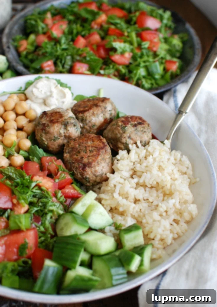 Sun-Kissed Mediterranean Turkey Meatballs 2 Mediterranean Baked Turkey Meatballs in a bowl, garnished with fresh herbs and a drizzle of sauce.