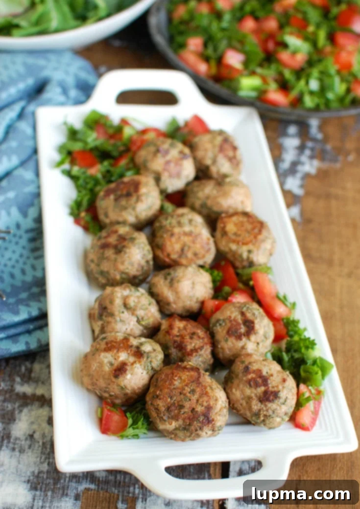 Sun-Kissed Mediterranean Turkey Meatballs 3 A platter of golden-brown Mediterranean Baked Turkey Meatballs ready to serve, garnished with fresh herbs.