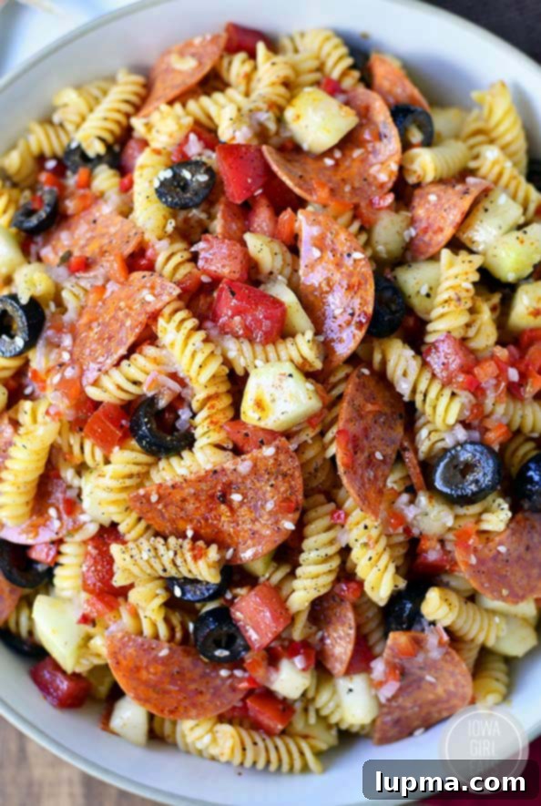 Cool Off with 13 Refreshing Summer Salads 4 A vibrant bowl of Summer Orzo Pasta Salad with tomatoes, olives, and feta cheese.