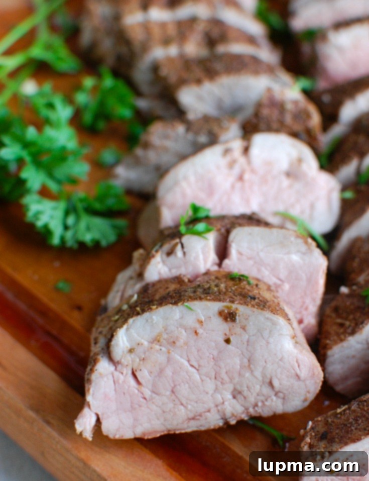 Sun-Drenched Mediterranean Pork Tenderloin 4 Hands rubbing Mediterranean spice mixture onto pork tenderloin on a cutting board, preparing it for baking.