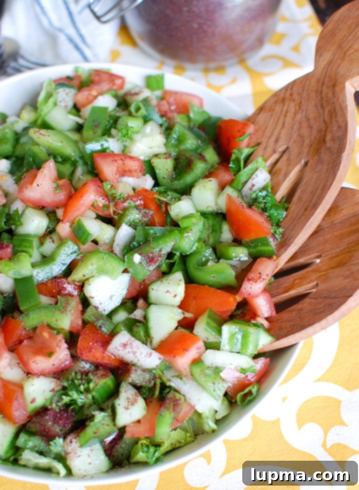 Fresh & Easy Lebanese Salad 2 Easy Lebanese Salad with Wood Spoons in a white bowl, showcasing fresh chopped vegetables.