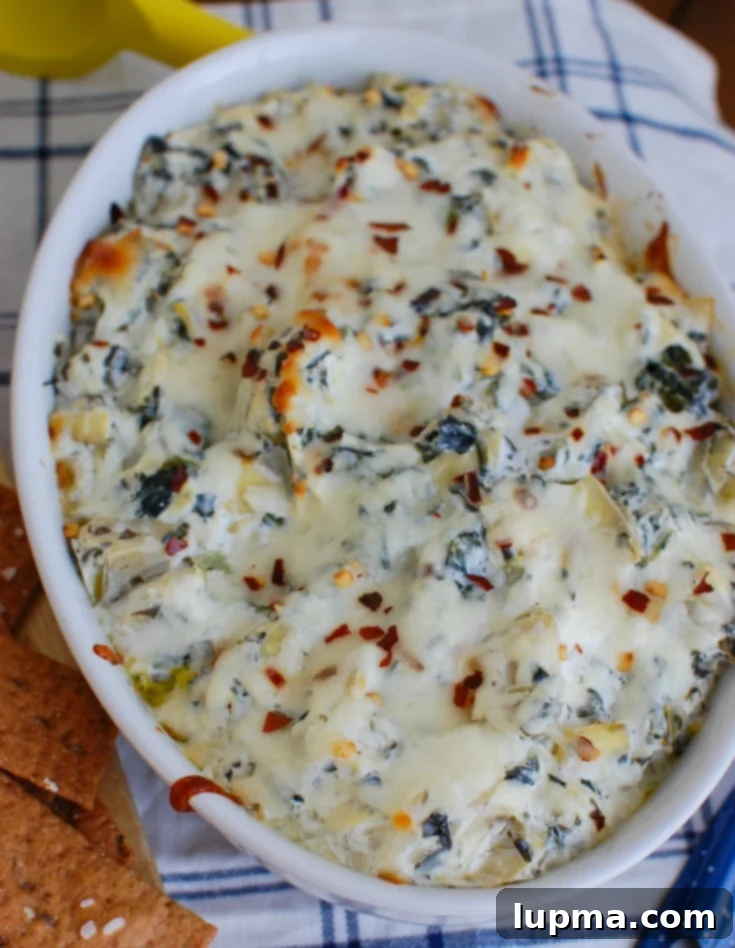 Zesty Lemon Spinach Artichoke Dip 2 Warm Lemon Spinach Artichoke Dip in a white bowl with a napkin on the side