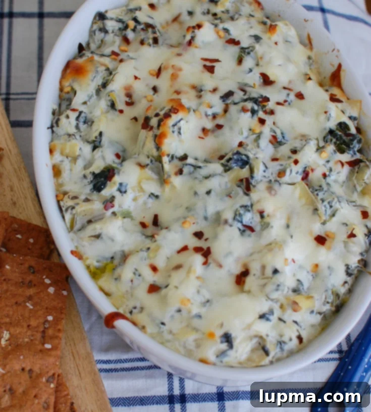 Zesty Lemon Spinach Artichoke Dip 5 Overhead shot of Lemon Spinach Artichoke Dip in a white bowl, ready to be served