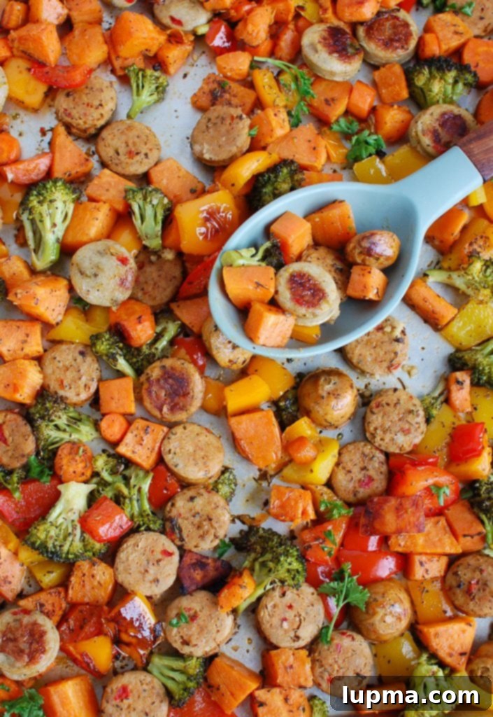 Golden Roasted Chicken Sausage and Garden Veggies 5 A close-up of a serving of Sheet Pan Chicken Sausage and Vegetables, ready to be enjoyed, with a spoon for serving.