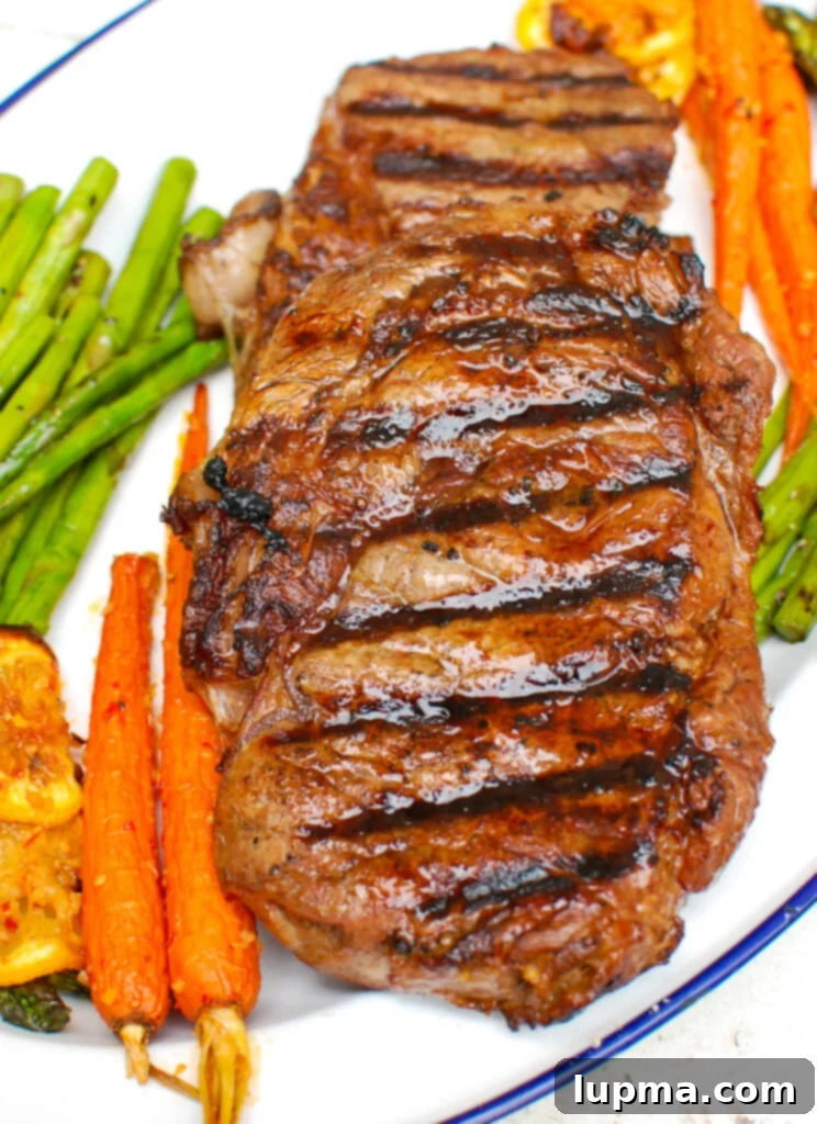 Zesty Lemon Garlic Butter Grilled Ribeye 3 Marinated Lemon Garlic Butter Grilled Ribeye steak resting on a cutting board, garnished with fresh herbs