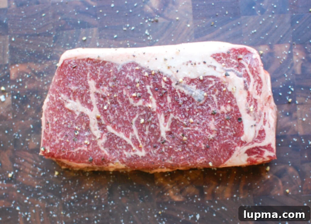 Zesty Lemon Garlic Butter Grilled Ribeye 4 Sliced Lemon Garlic Butter Grilled Ribeye on a cutting board, sprinkled with sea salt and fresh herbs