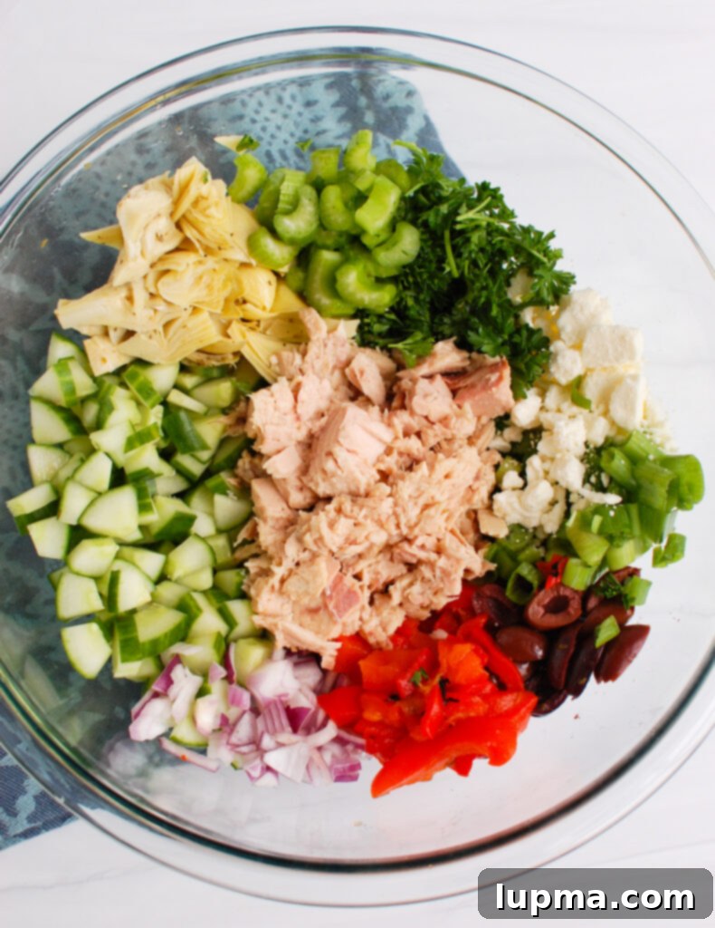 Sun-Kissed Mediterranean Tuna Medley 3 A selection of fresh ingredients for Mediterranean Tuna Salad laid out on a white surface.