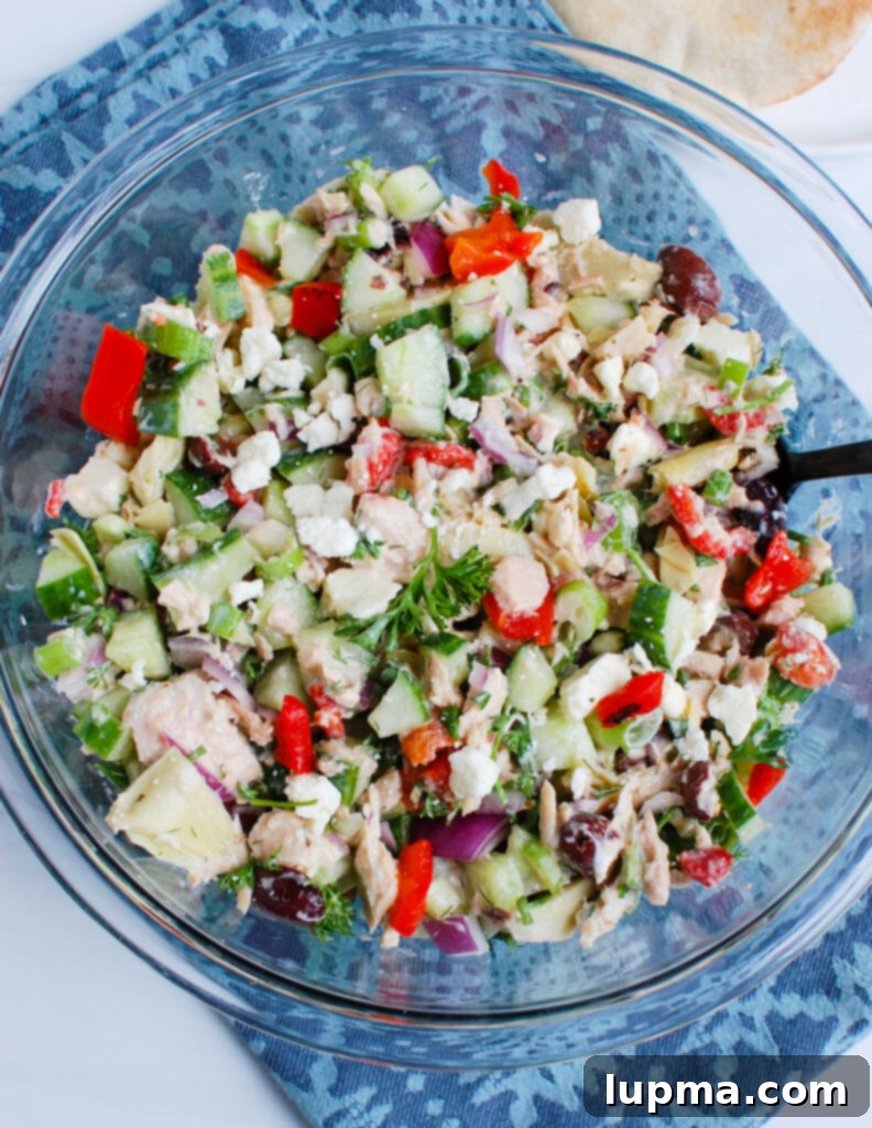 Sun-Kissed Mediterranean Tuna Medley 4 A bowl of Mediterranean Tuna Salad next to a blue napkin, highlighting the fresh ingredients.