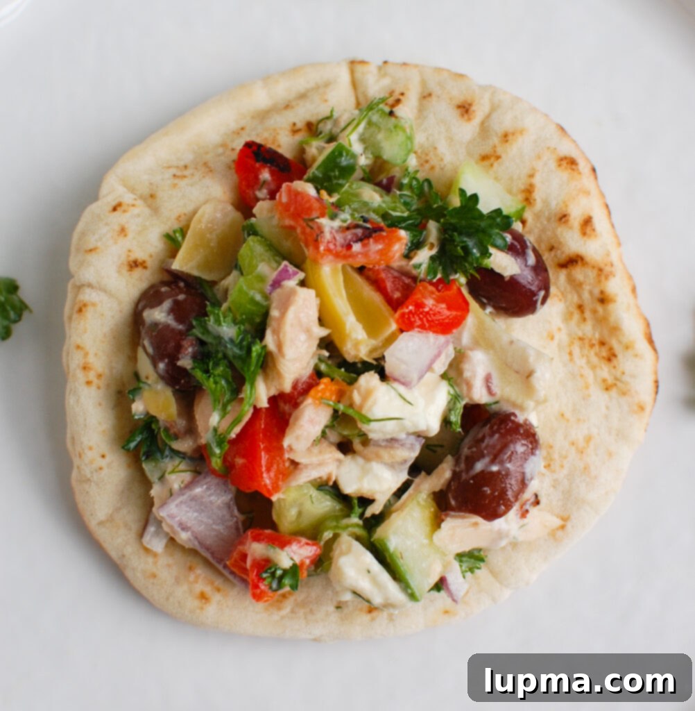 Sun-Kissed Mediterranean Tuna Medley 6 Mediterranean Tuna Salad served on warm pita bread, garnished with fresh herbs.