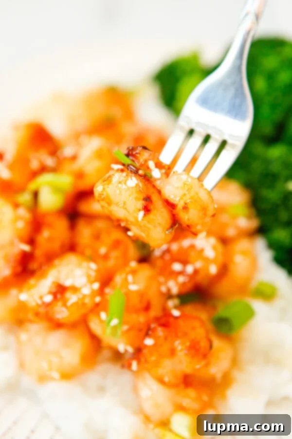 Sweet Heat Sriracha Shrimp 2 Honey Garlic Sriracha Shrimp with a fork, ready to be enjoyed