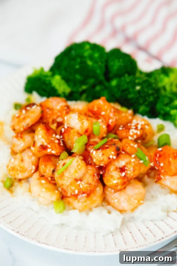 Sweet Heat Sriracha Shrimp 4 Honey Garlic Sriracha Shrimp served with fresh steamed broccoli on a white plate