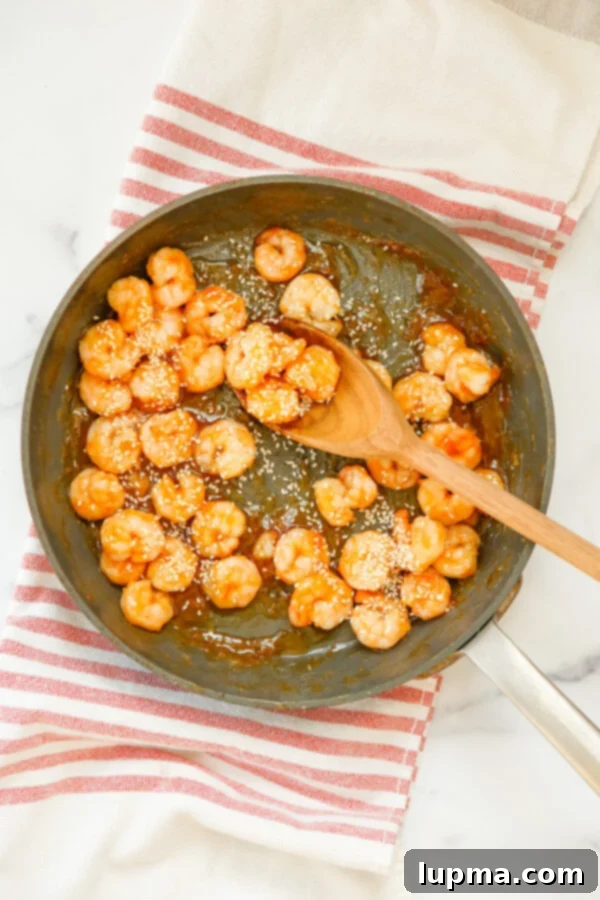 Sweet Heat Sriracha Shrimp 7 Close-up of Honey Garlic Sriracha Shrimp in a skillet, tossed with fresh green onions