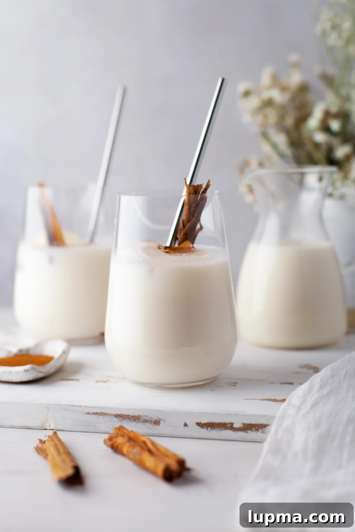 The Ultimate Horchata Recipe 6 Multiple glasses of Horchata on a tray, ready to be served, with ice and garnishes.