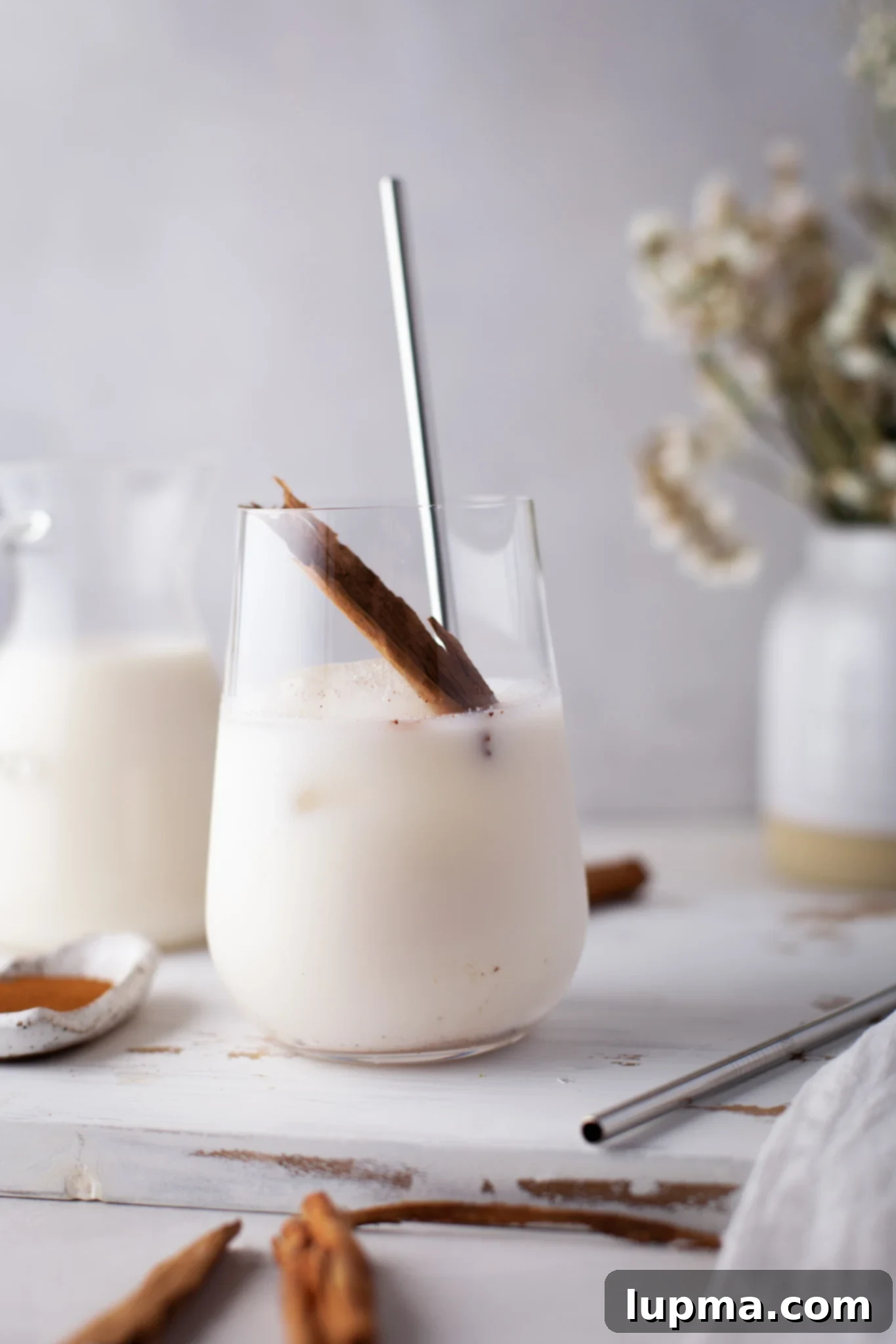 The Ultimate Horchata Recipe 7 Horchata in a glass, with cinnamon sticks as a garnish, illustrating the refreshing qualities and key flavoring.