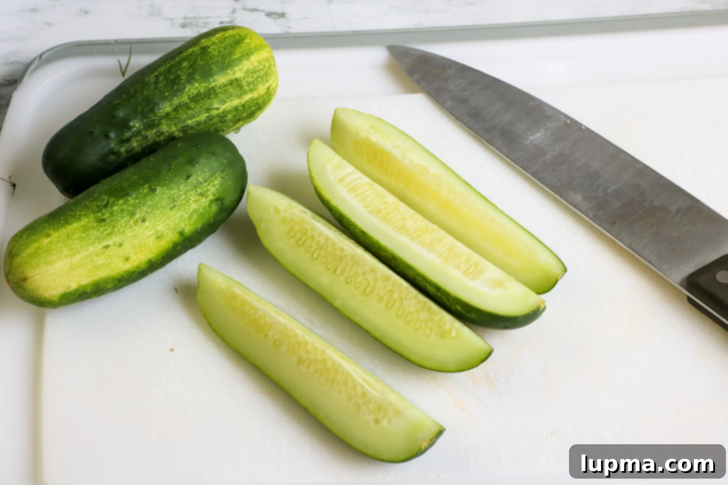 Speedy Refrigerator Dill Pickles 3 Close-up of freshly made Refrigerator Dill Pickles on a wooden cutting board, ready to be served.