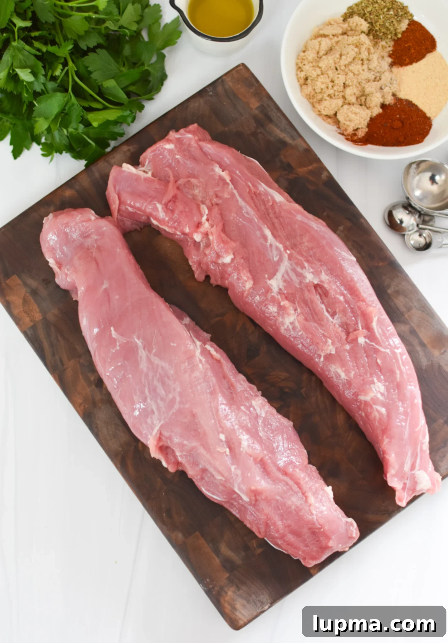 Juicy Air Fryer Pork Tenderloin 3 Air Fryer Pork Tenderloin on a cutting board, sliced and ready to serve.