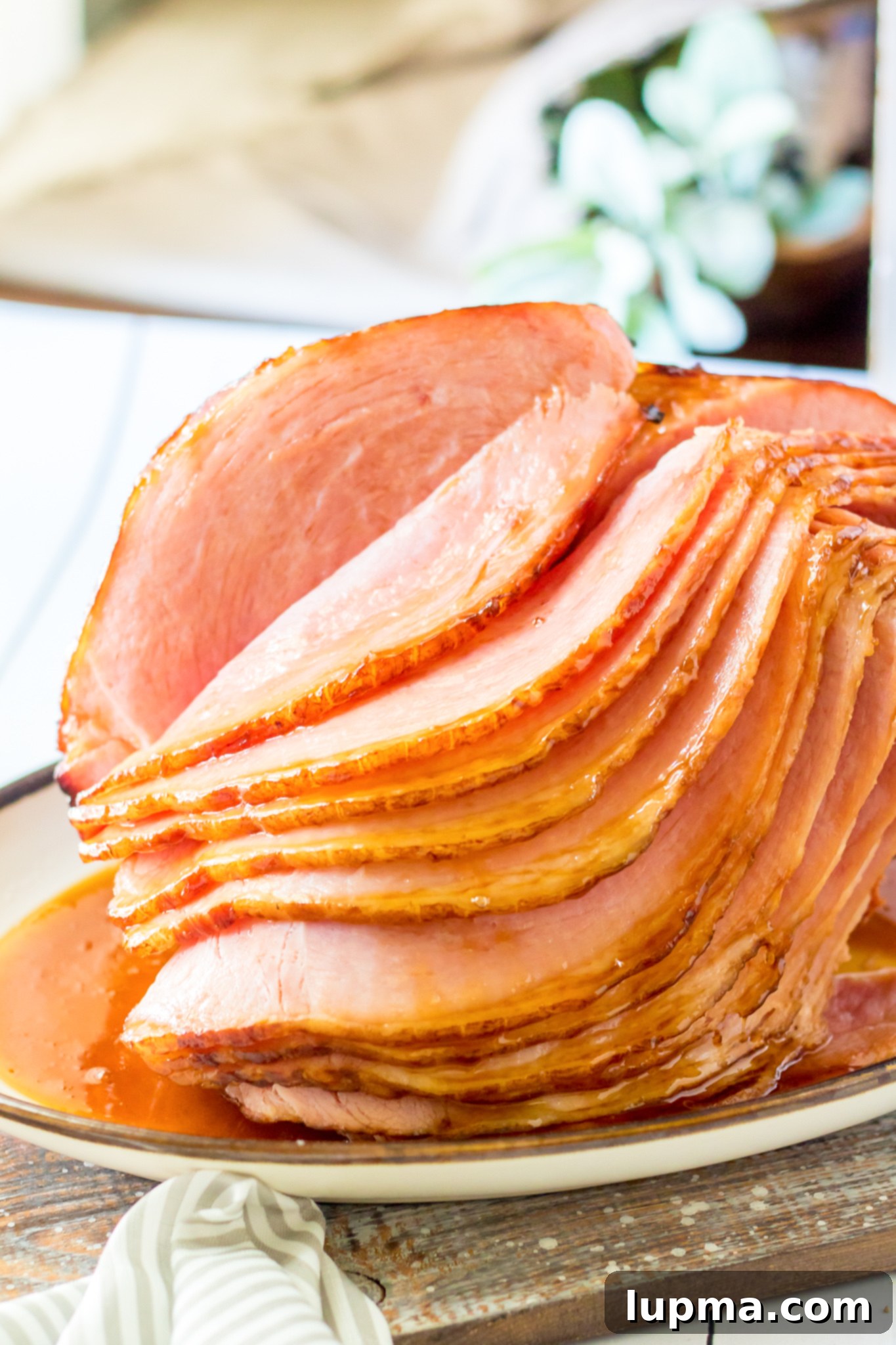 Sweet and Sticky Apple Cider Glazed Ham 2 Delicious Apple Cider Glazed Ham on a serving platter, ready for carving.
