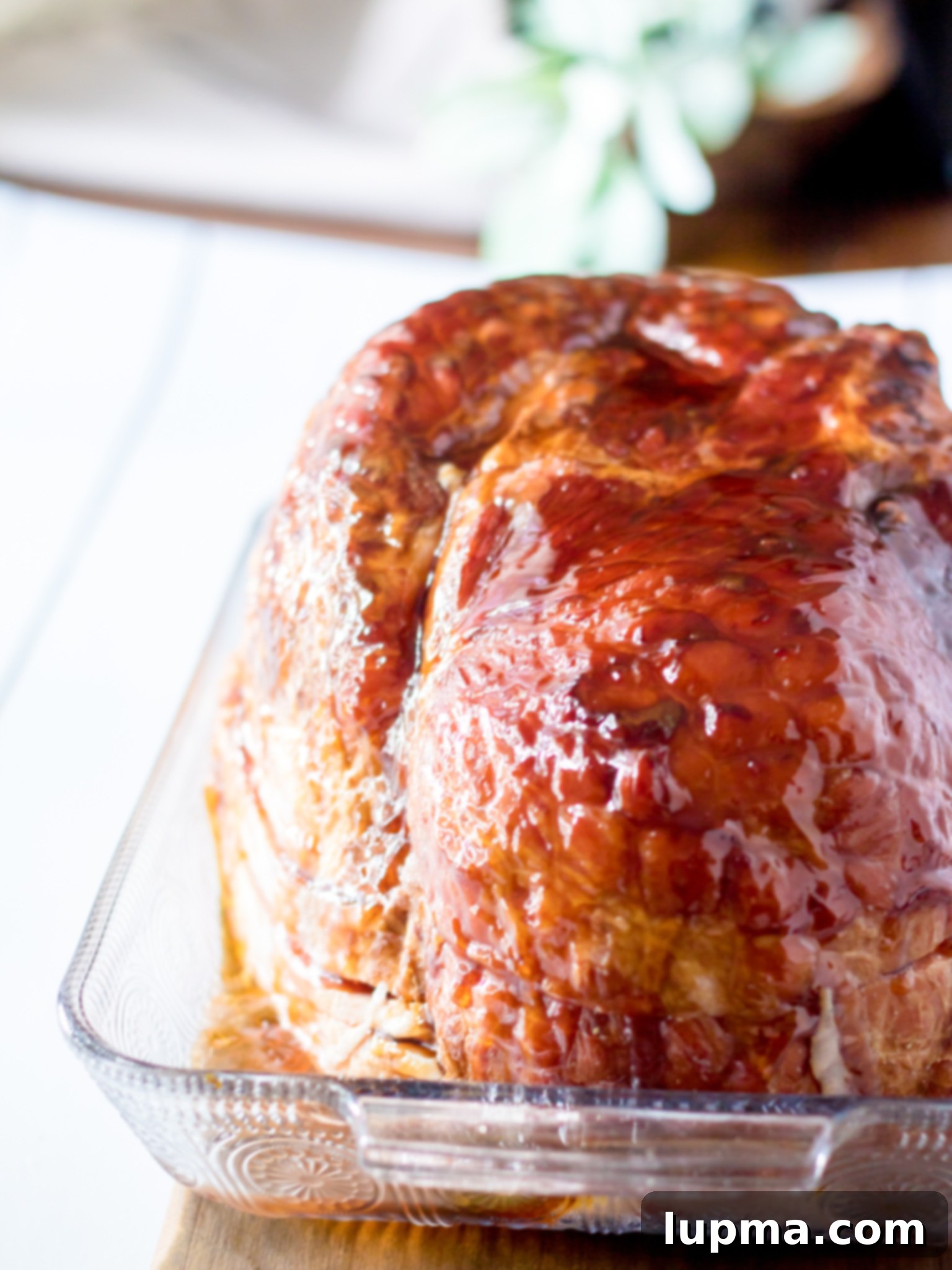 Sweet and Sticky Apple Cider Glazed Ham 7 Glazed spiral ham resting on a cutting board, ready for carving.