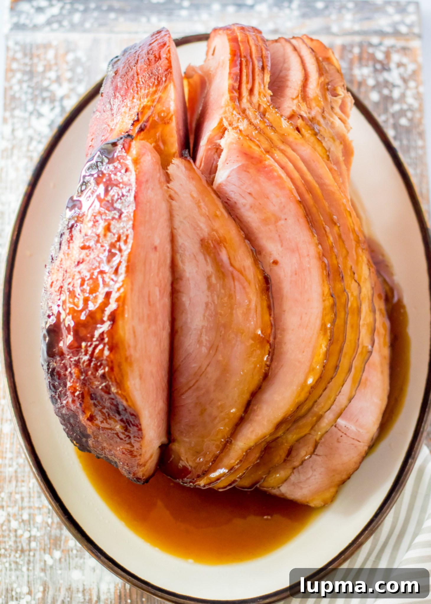 Sweet and Sticky Apple Cider Glazed Ham 8 Full Apple Cider Glazed Ham served in a large baking dish.