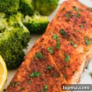 Speedy Air Fryer Salmon Perfection 8 Air Fryer Salmon 1200 x 1200 - A perfectly cooked salmon fillet, crispy on the outside and flaky within, is beautifully presented on a plate with fresh herbs and a lemon wedge. The golden-brown crust highlights the deliciousness achieved by air frying, making it an ideal quick and healthy meal option.