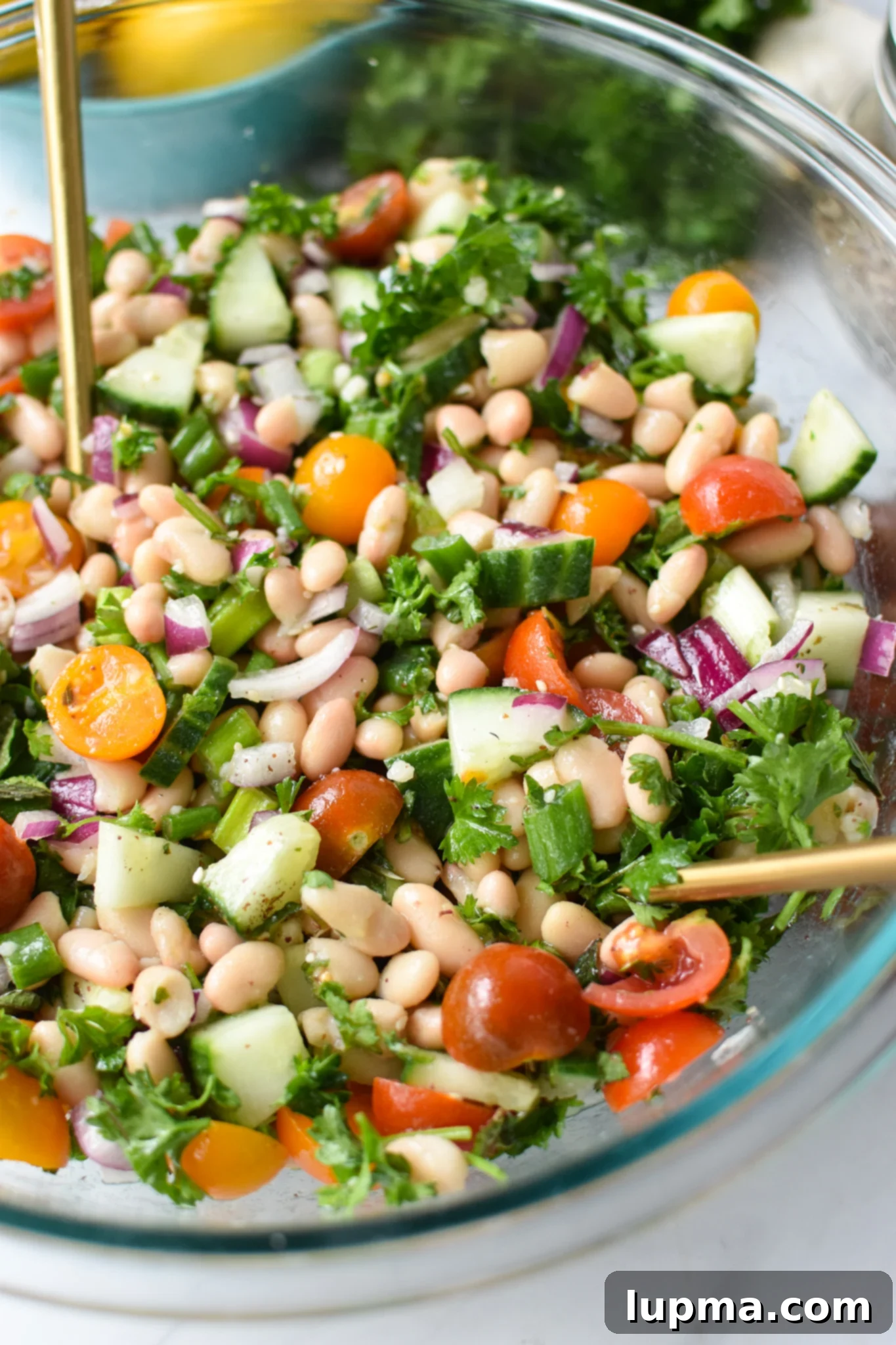 Sun-Drenched White Bean Medley 2 Mediterranean White Bean Salad with gold spoons.