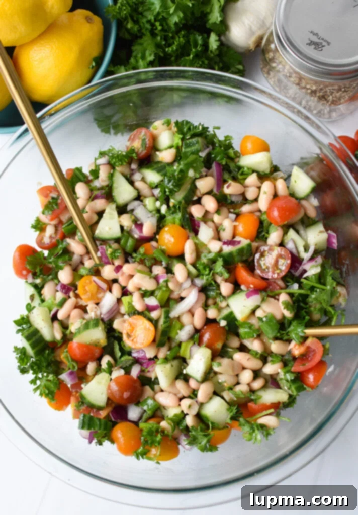 Sun-Drenched White Bean Medley 6 Mediterranean White Bean Salad with gold serving spoons.