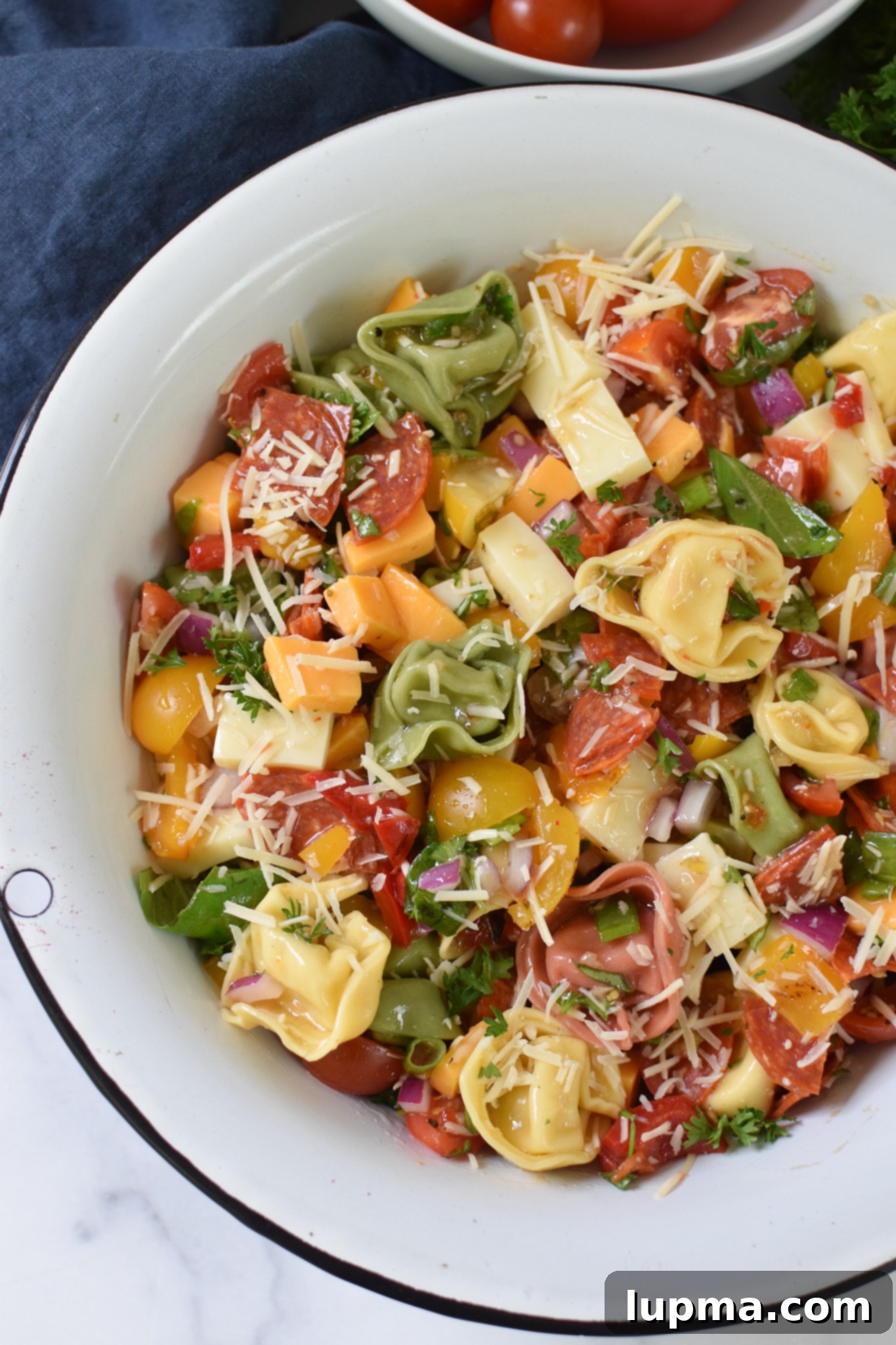 Speedy Italian Tortellini Salad 4 A close-up view of the vibrant Italian Tortellini Salad in a white serving bowl, showcasing the perfectly coated tortellini and colorful mix of ingredients.