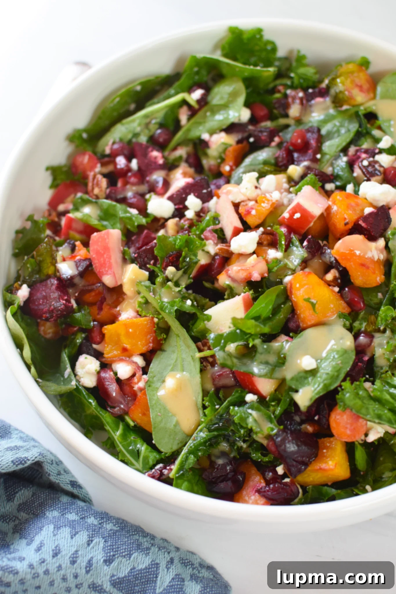 Autumn's Bounty Salad 2 A beautifully presented Fall Harvest Salad in a white bowl, showcasing roasted vegetables, greens, and vibrant toppings.