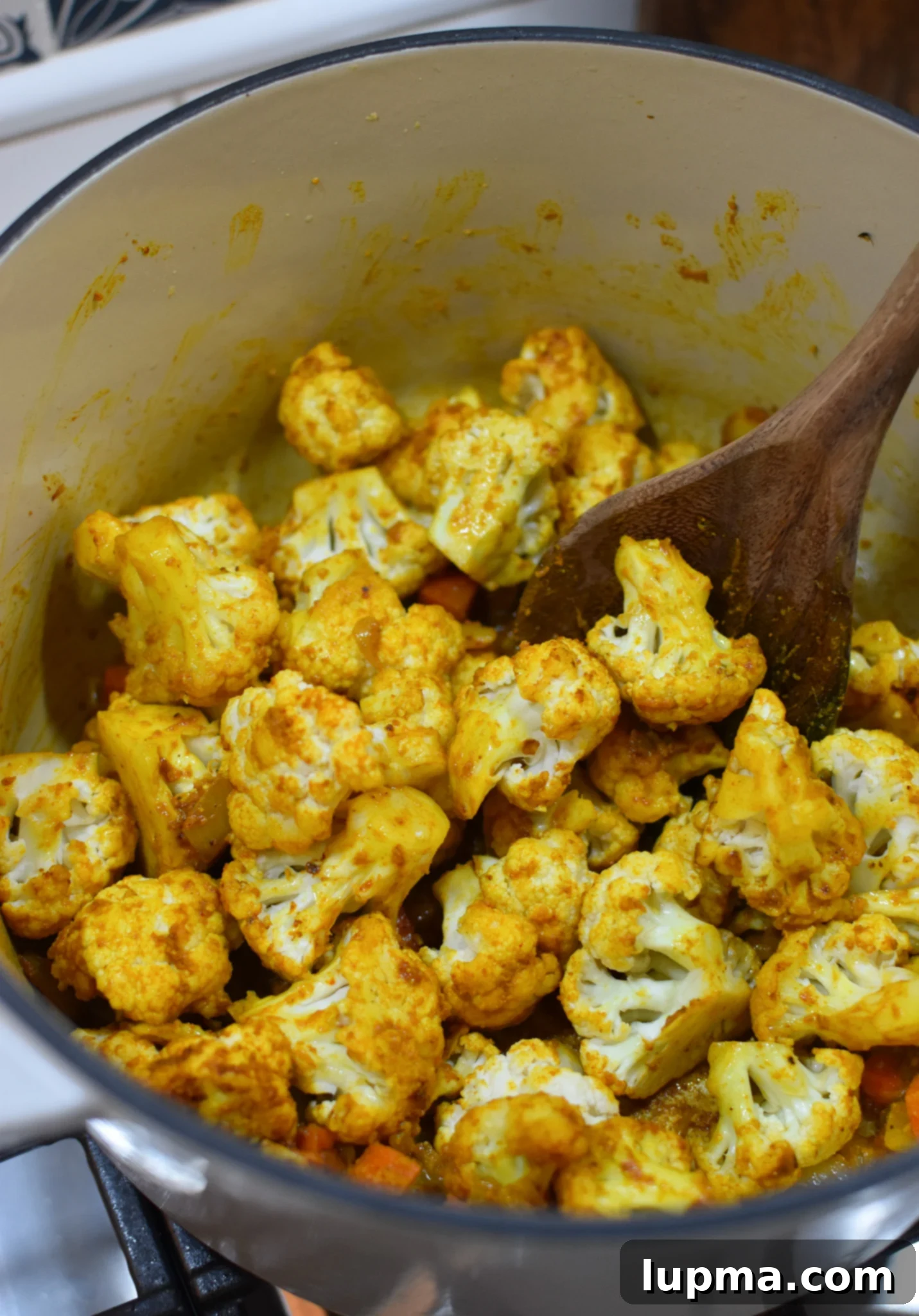 Velvet Cauliflower Puree 5 Cauliflower florets simmering in broth in a pot.