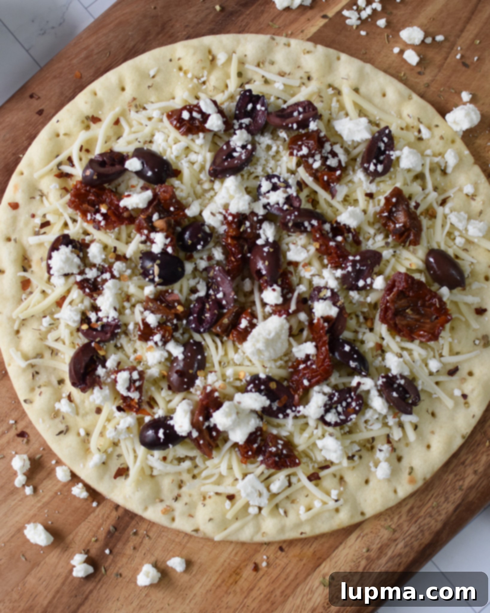 Hellenic Herb & Feta Pizza 5 Greek Pizza with cheese and sun-dried tomatoes on it.
