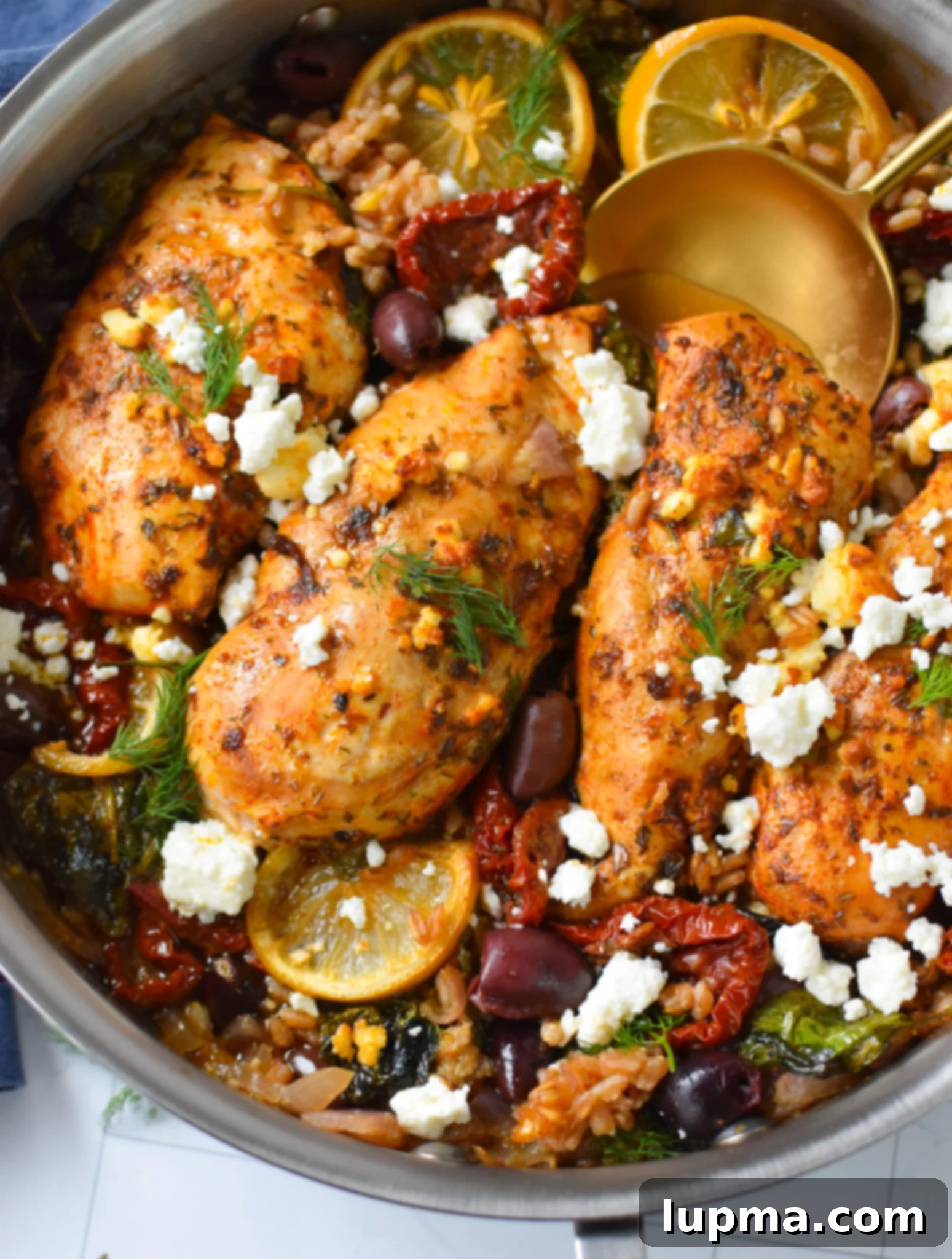 Roasted Chicken and Farro with Sun-dried Tomatoes 2 Sun-dried Tomato Farro Chicken Bake with a gold spoon, showcasing a hearty, comforting meal.