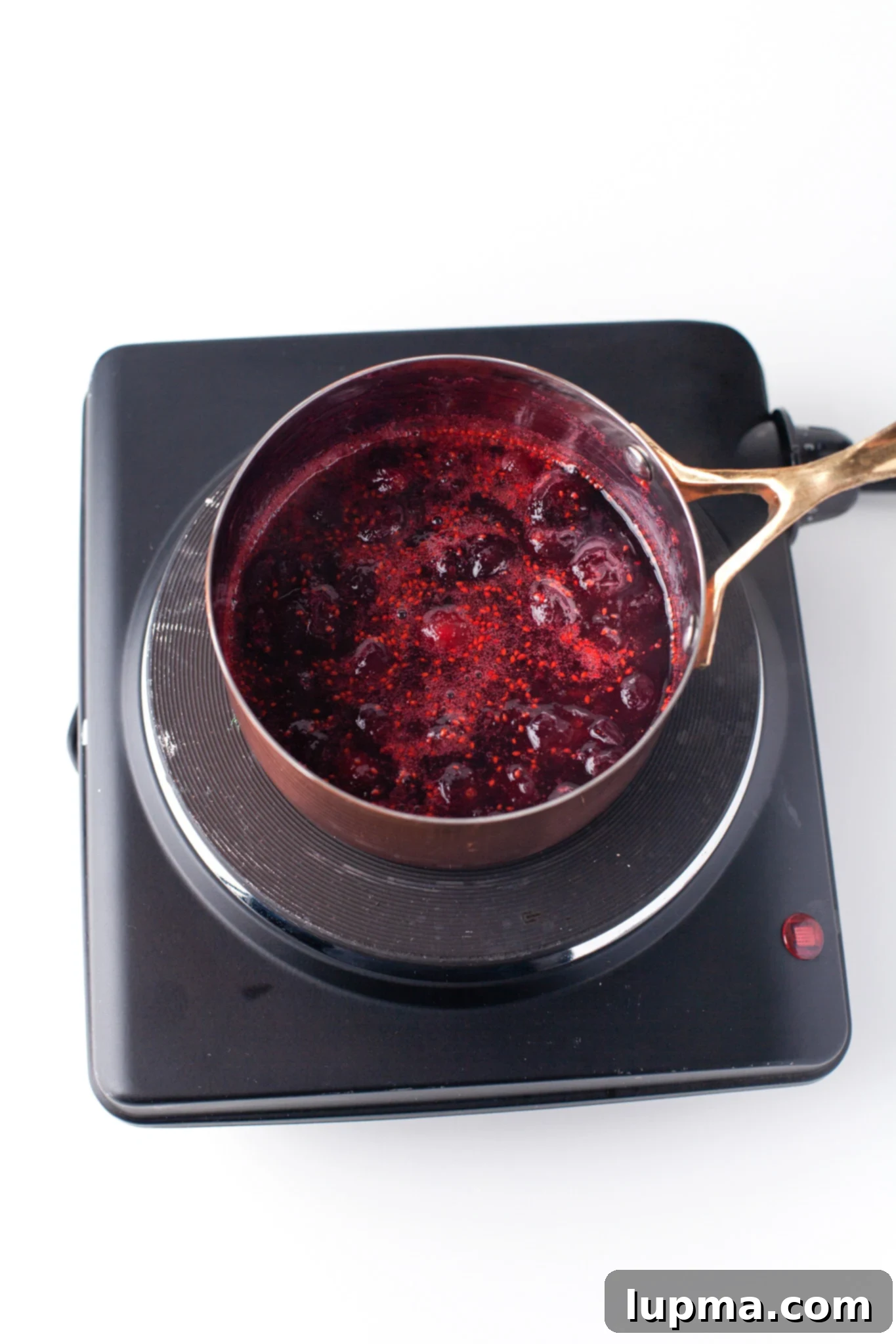 Vibrant Cranberry Aperol Spritz 5 Fresh cranberries simmering in a pot, making homemade cranberry syrup for the Aperol Spritz.