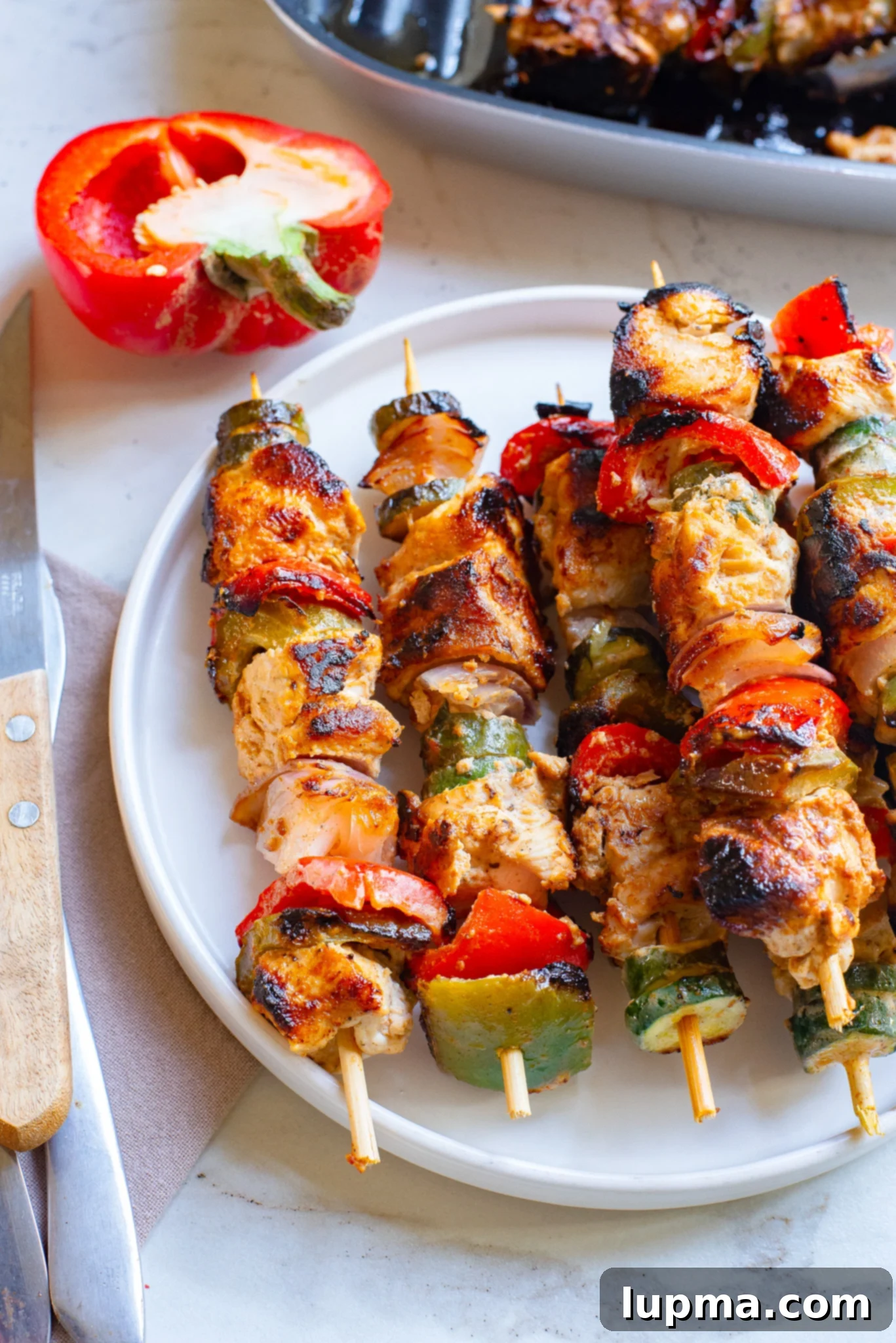 Zesty Greek Lemon Chicken Skewers 2 Platter of grilled Greek Marinated Chicken Kabobs with Lemon, garnished with fresh herbs.