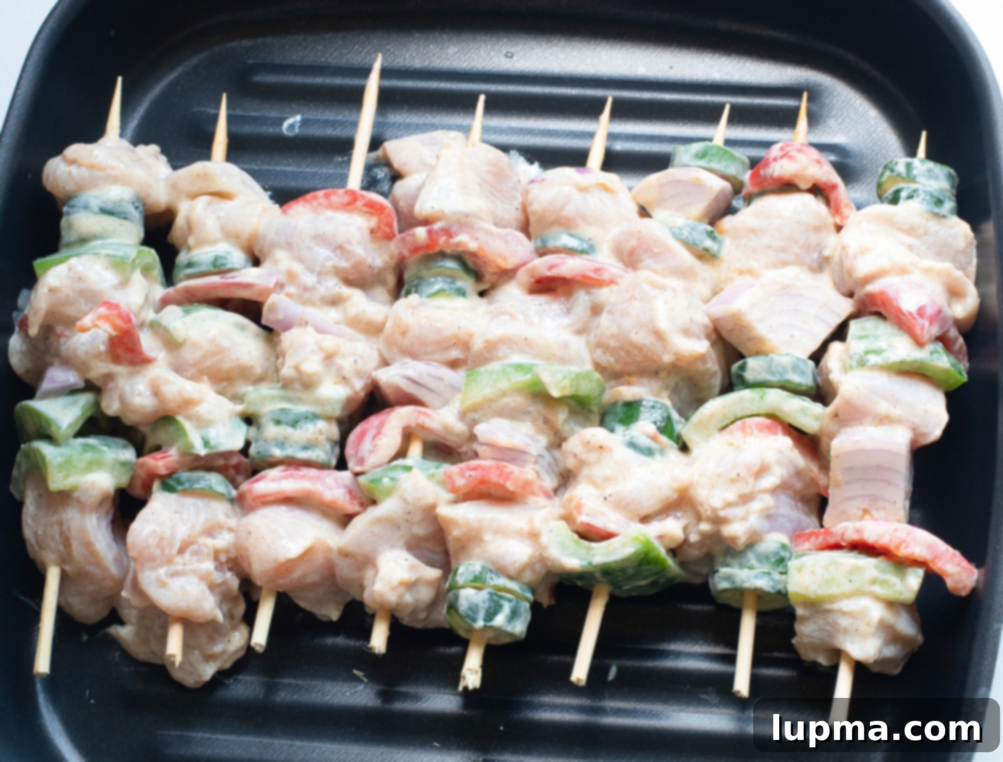 Zesty Greek Lemon Chicken Skewers 6 Greek Marinated Chicken Kabobs with Lemon cooking on a sizzling grill.