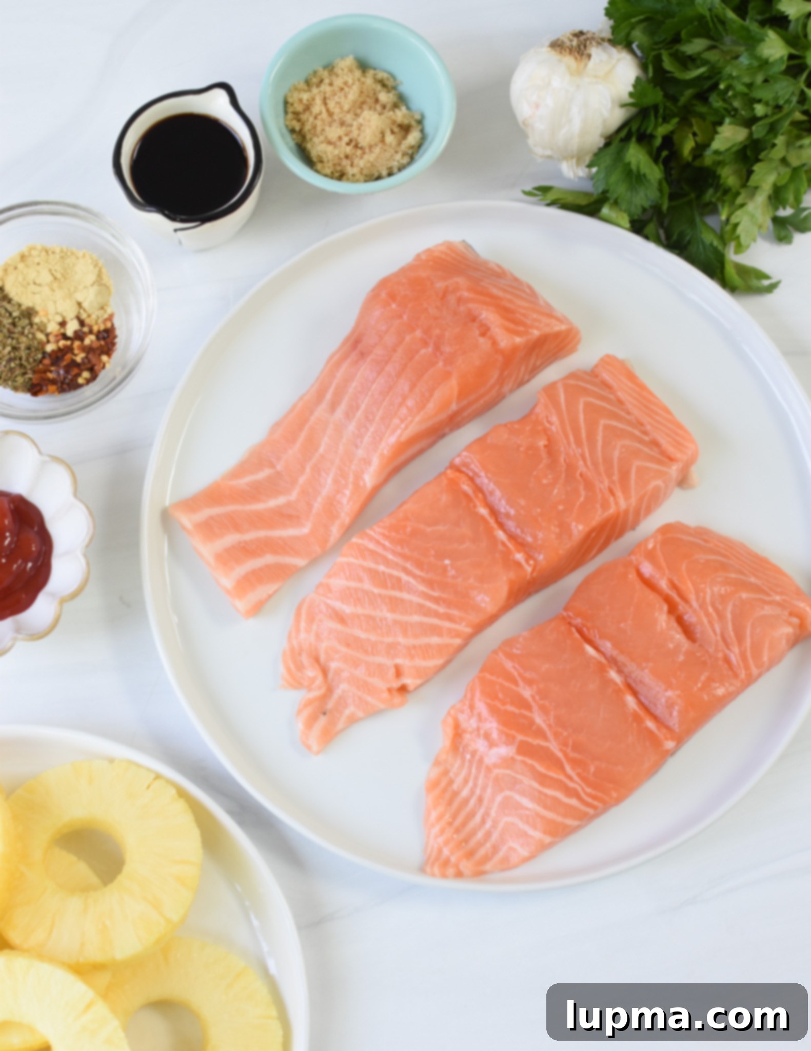 Aloha Grilled Salmon 4 All the ingredients laid out for Hawaiian Grilled Salmon, including salmon fillets, fresh pineapple, and various marinade components.