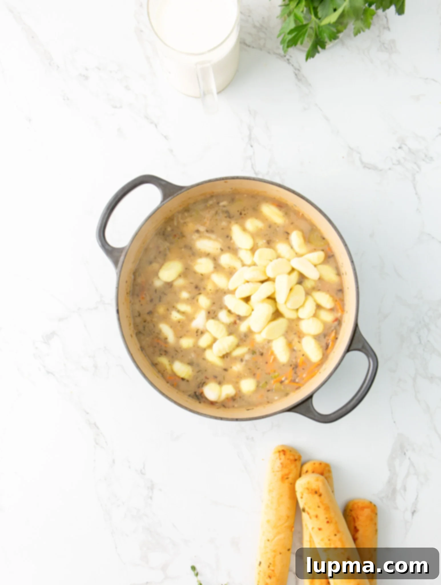 Homemade Olive Garden Style Chicken Gnocchi Soup 9 Pillowy potato gnocchi simmering in a creamy broth inside a pot, cooking for the Copycat Olive Garden Chicken Gnocchi Soup.