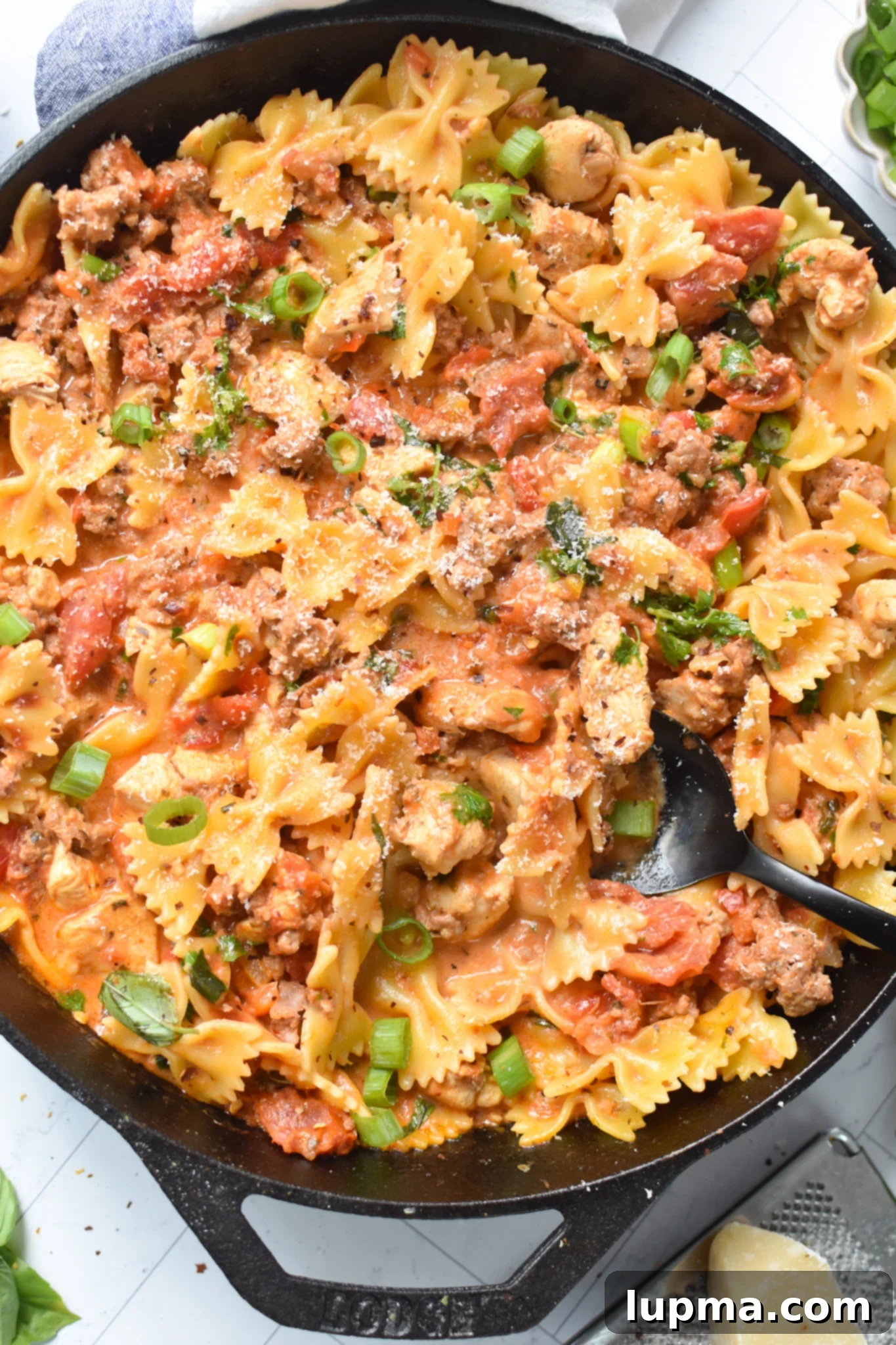 The Ultimate Creamy Chicken & Chorizo Pasta 2 Creamy Chicken and Chorizo Pasta Recipe with black spoon.