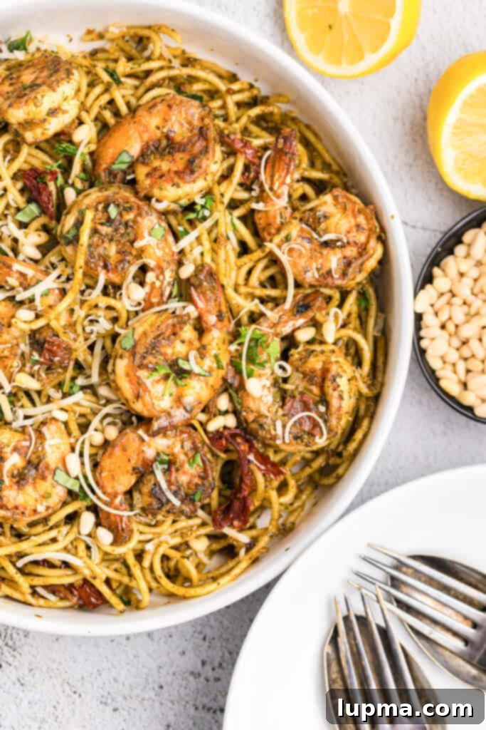 Vibrant Shrimp Pesto Pasta 2 Shrimp Pesto Pasta in a bowl, garnished with fresh basil